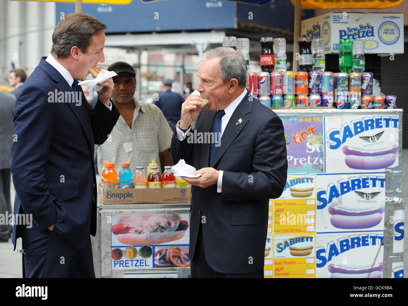 Premierminister David Cameron genießt einen Hotdog mit dem New Yorker Bürgermeister Michael Bloomberg, als er heute im Rahmen seines zweitägigen Besuchs in den USA von Washington DC in der Penn Station ankam. Stockfoto