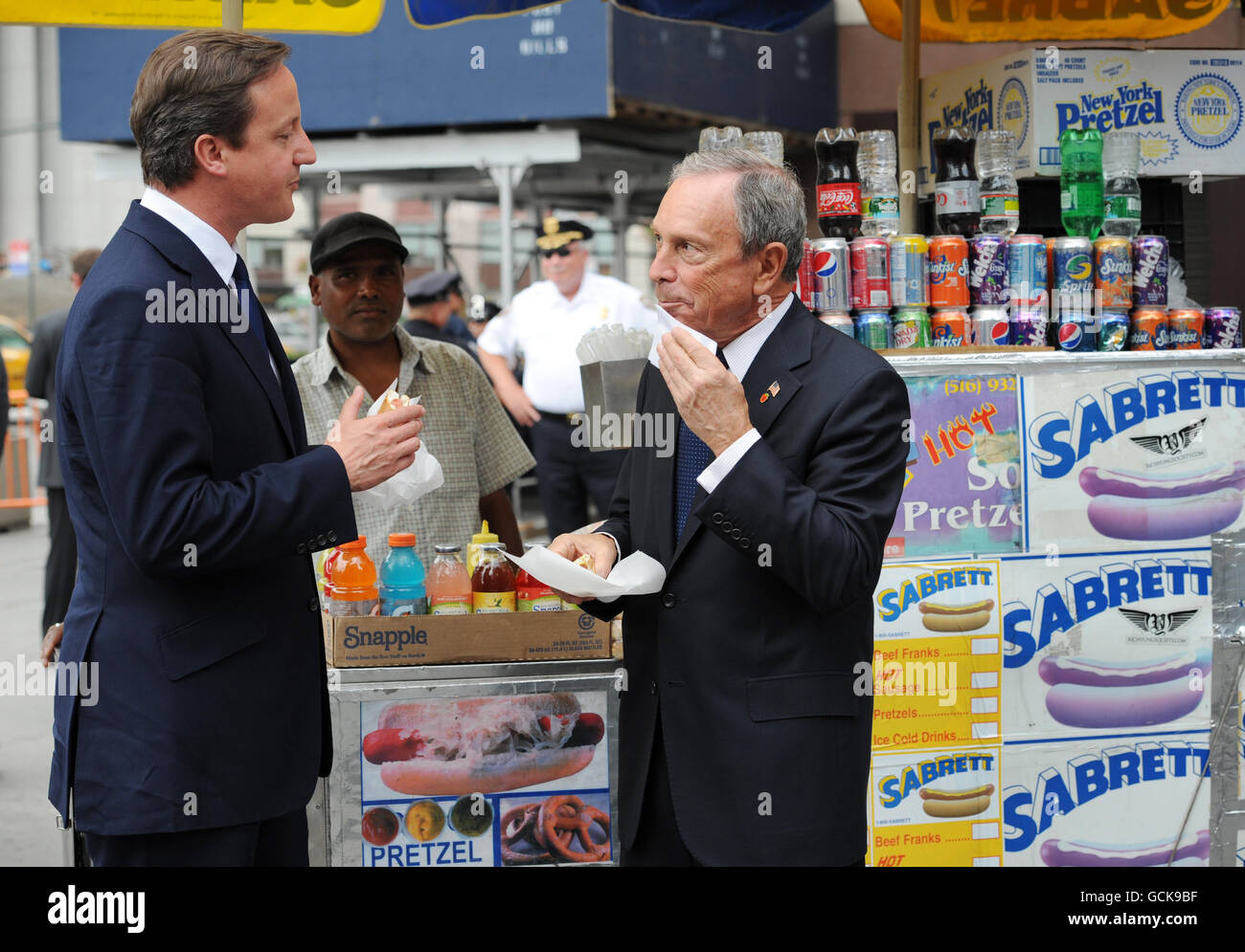 Premierminister David Cameron genießt einen Hotdog mit dem New Yorker Bürgermeister Michael Bloomberg, als er heute im Rahmen seines zweitägigen Besuchs in den USA von Washington DC in der Penn Station ankam. Stockfoto