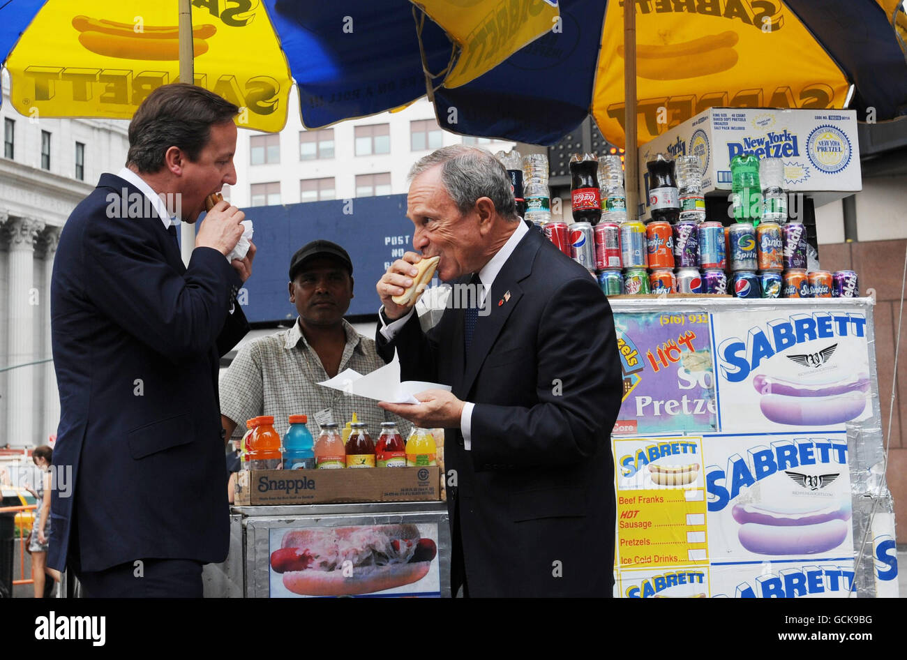 Premierminister David Cameron genießt einen Hotdog mit dem New Yorker Bürgermeister Michael Bloomberg, als er heute im Rahmen seines zweitägigen Besuchs in den USA von Washington DC in der Penn Station ankam. Stockfoto
