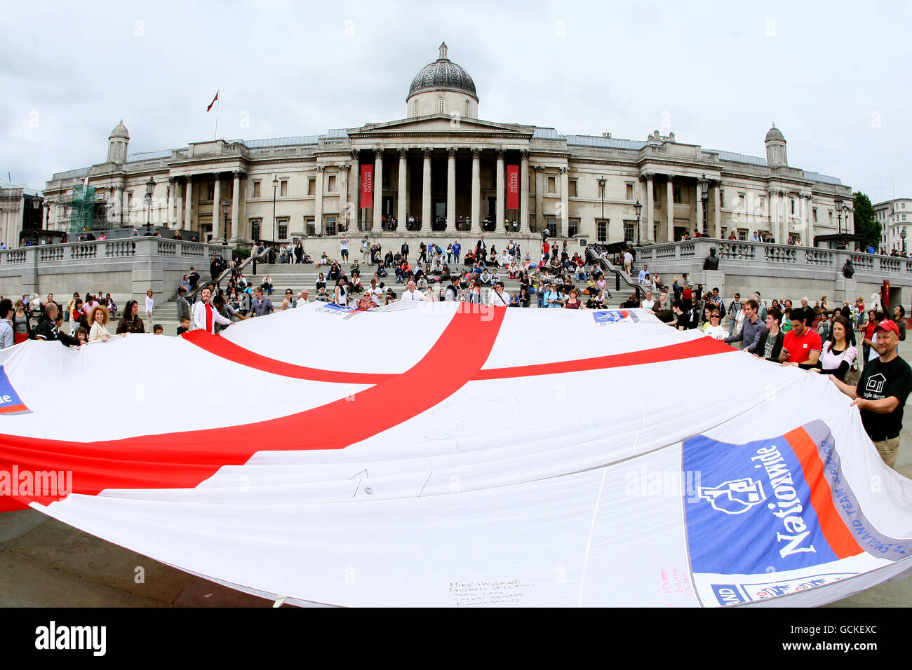 Vor dem WM-Spiel gegen Algerien zeigen die Menschen Unterstützung für die englische Fußballmannschaft mit einer riesigen Saint-George-Cross-Flagge auf dem Trafalgar Square im Zentrum von London Stockfoto
