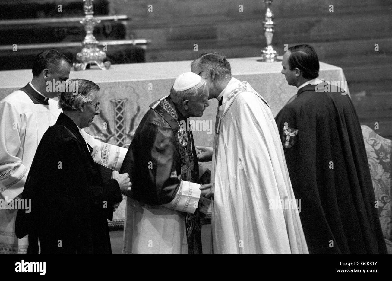 Der Erzbischof von Canterbury, Dr. Robert Runcie, und Papst Johannes Paul II. Küssen sich vor dem Kirchenschiff in der Kathedrale von Canterbury zu Beginn eines historischen Gottesdienstes. Stockfoto
