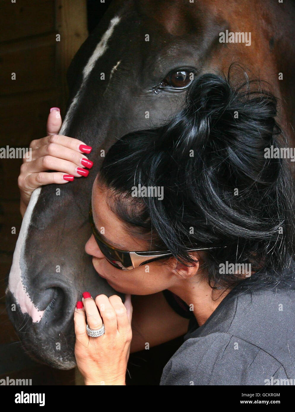 Katie Price umarmt eines der Pferde während eines Besuchs im Horse Refuge in Wittersham, Kent, das von einer Schließung bedroht ist. Stockfoto