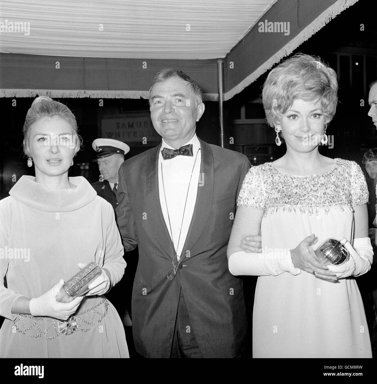 Schauspieler James Mason, Mitte, begleitet die Hollywood-Schauspielerinnen Joanne Woodward, Left, Ehefrau von Paul Newman, und Barbara Rush bei der Premiere seines neuen Films 'Mayerling'. Stockfoto