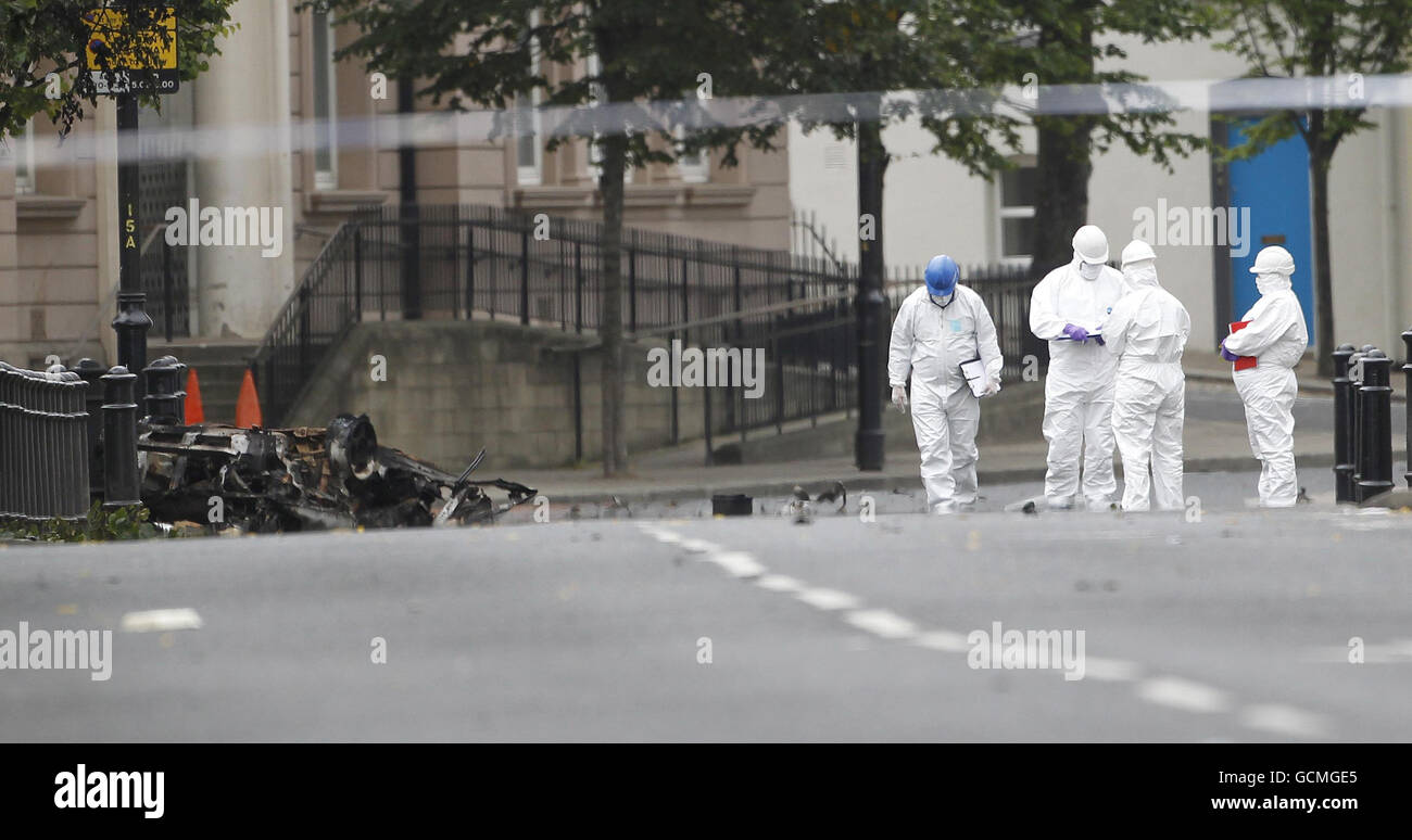 Forensische Beamte untersuchen den Ort, an dem eine Autobombe vor der Polizeiwache Strand Road in Londonderry explodierte. Stockfoto