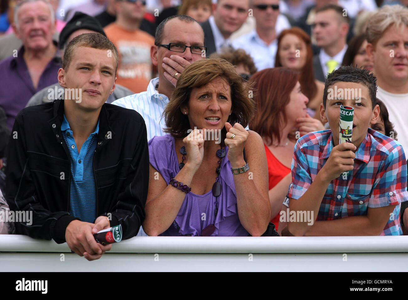 Racegoers schauen auf den riesigen Fernsehbildschirm, während sie Sehen Sie sich das Rennen im Sandown Park an Stockfoto