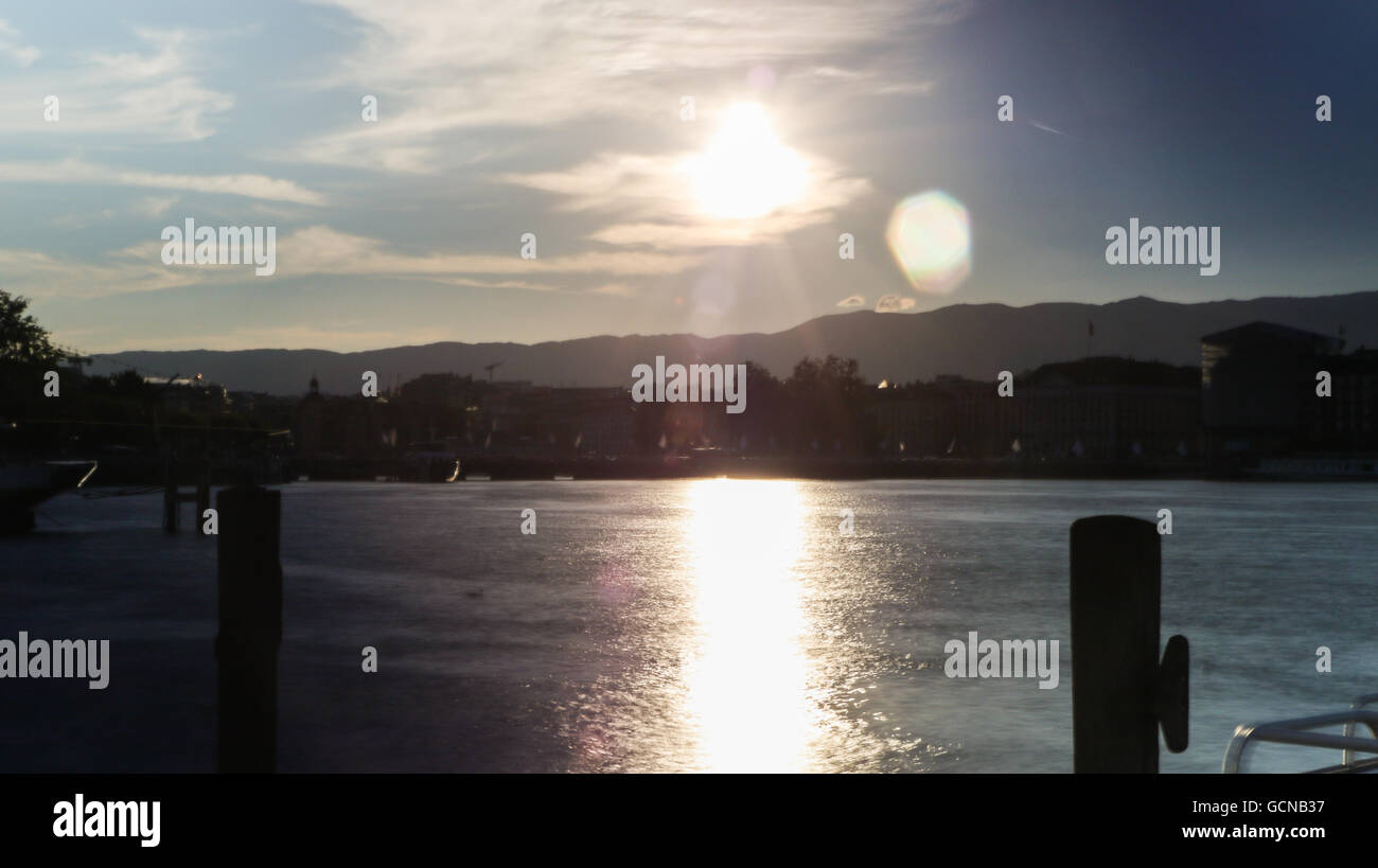Sonnenuntergang mit Lens Flare gesehen vom Quai Gustave-Ador in Genf, Schweiz Stockfoto