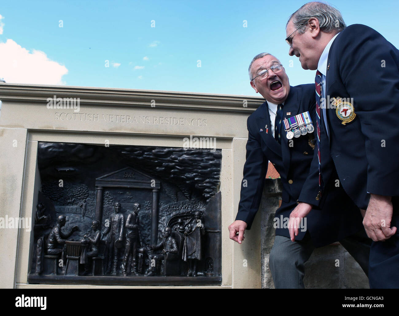 Die Veteranen Andrew Carr RAF (rechts) und Kenny Kerr Royal Marines schauen sich eine neue Bronzeskulptur an, um 100 Jahre Veteranenresidenz in Edinburgh zu markieren. Stockfoto