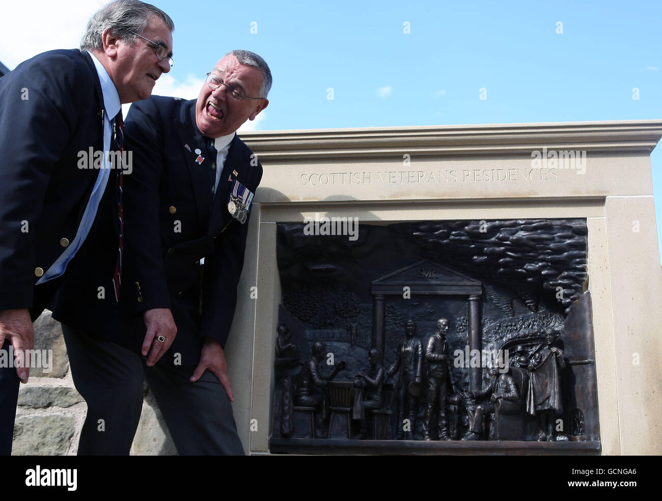 Die Veteranen Andrew Carr RAF (links) und Kenny Kerr Royal Marines schauen sich eine neue Bronzeskulptur an, um 100 Jahre Veteranenresidenz in Edinburgh zu markieren. Stockfoto