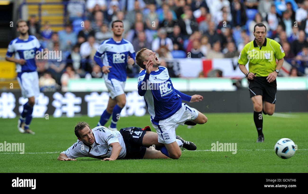 Sebastian Larsson von Birmingham City hat nach einem Angriff von Schmerzen Kevin Davies von Bolton Wanderers (links) Stockfoto