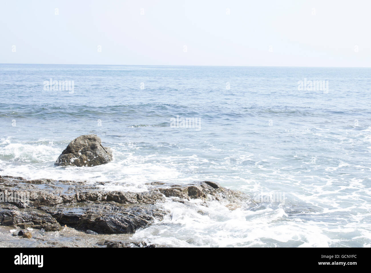 Wellen schlagen Felsen Stockfoto