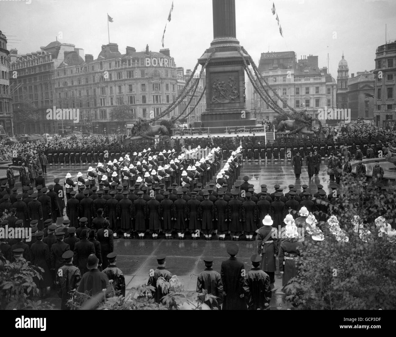Auf dem Trafalgar Square in London, einem regnerisch durchnässten Trafalgar Square, sind die Royal Navy und die Marine Wachen aufmerksam, als der Herzog von Edinburgh (rechts) seine Inspektion bei der Trafalgar Day Zeremonie macht. Die Zeremonie erinnert an den 150. Jahrestag der Schlacht. Stockfoto