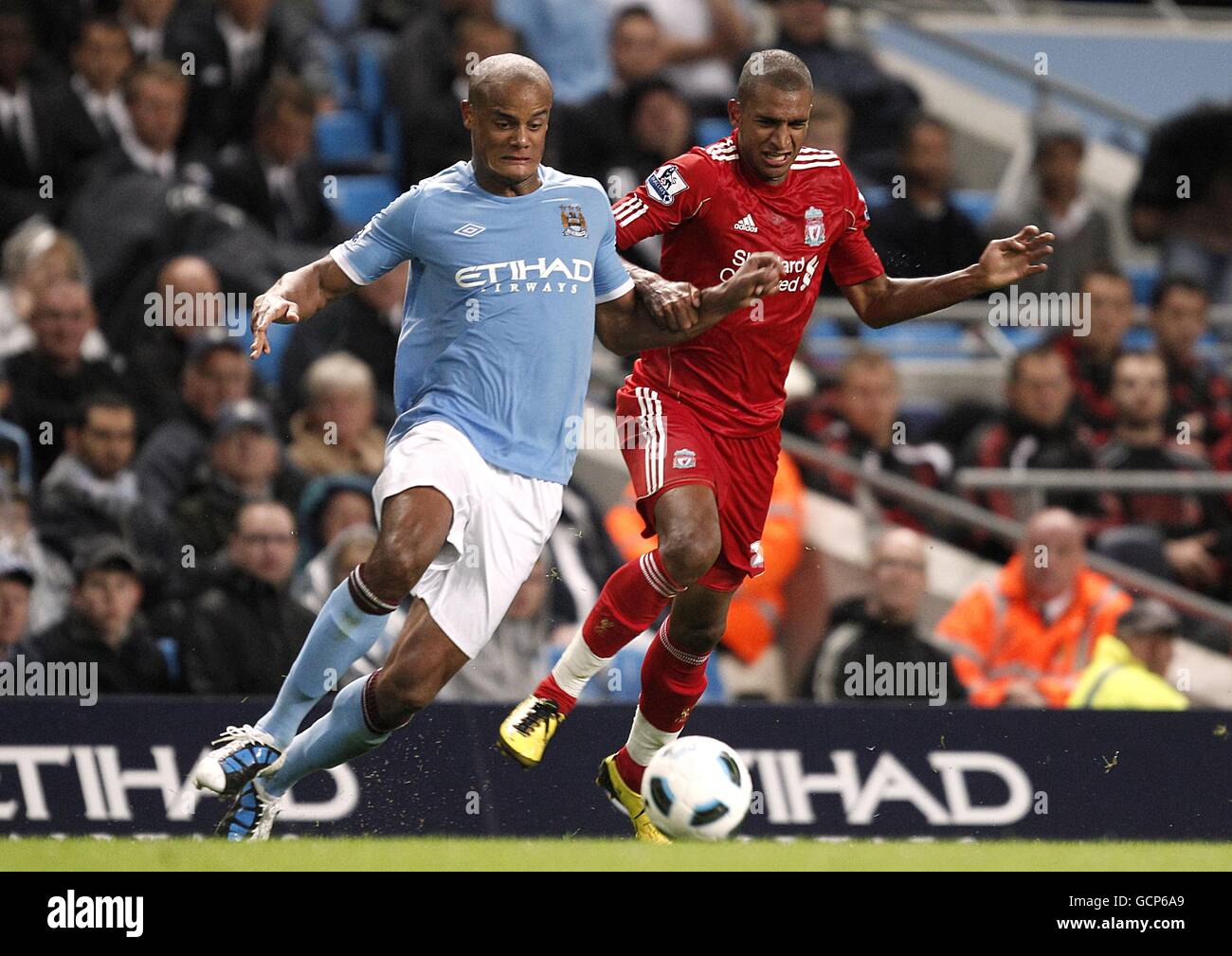 Fußball - Barclays Premier League - Manchester City / Liverpool - City of Manchester Stadium. Vincent Kompany (links) von Manchester City und David Ngog von Liverpool kämpfen um den Ball Stockfoto