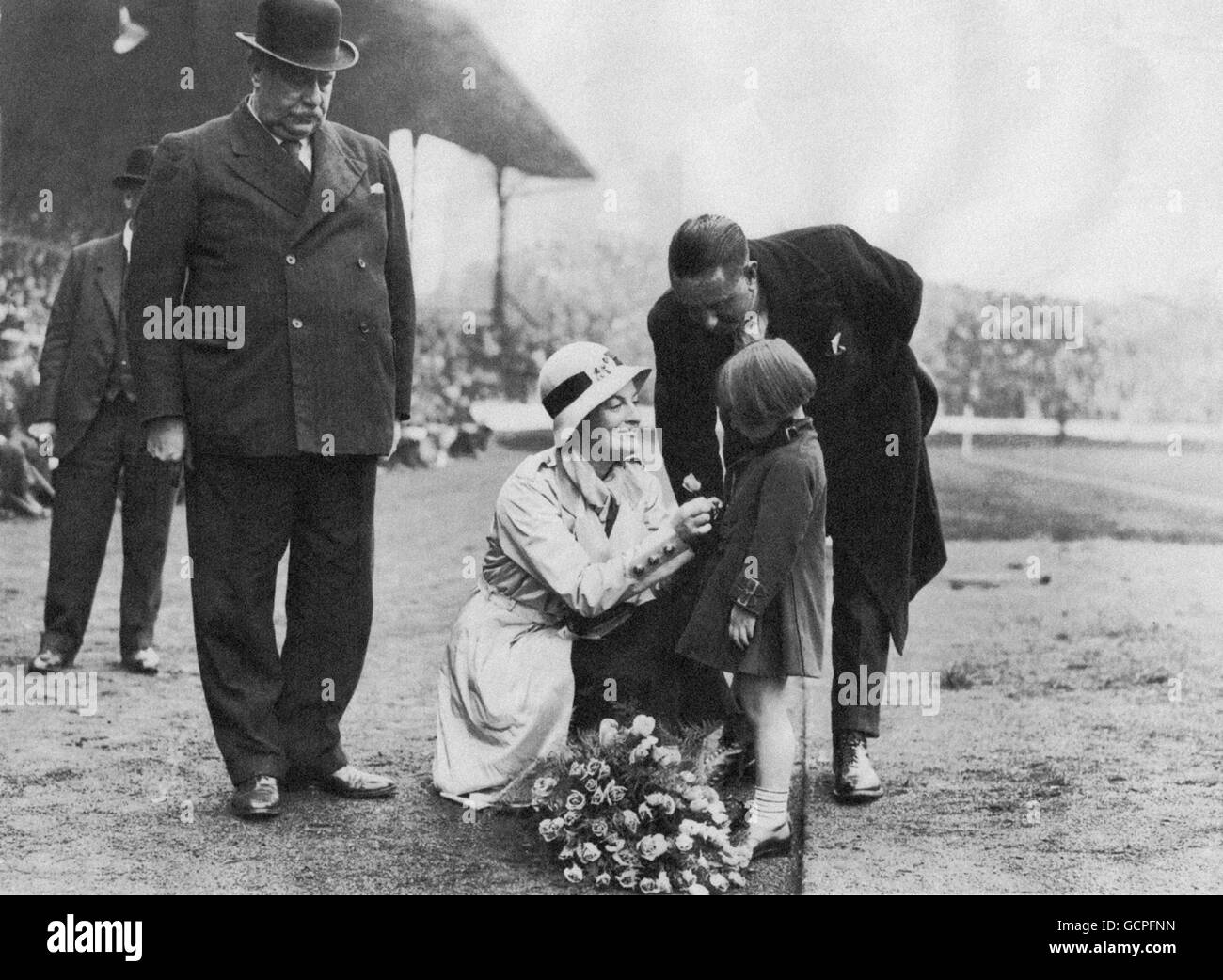 Ein junges Mädchen überreicht Sänger Gracie Fields vor Beginn des Spiels einen Blumenstrauß an der Stamford Bridge. Stockfoto