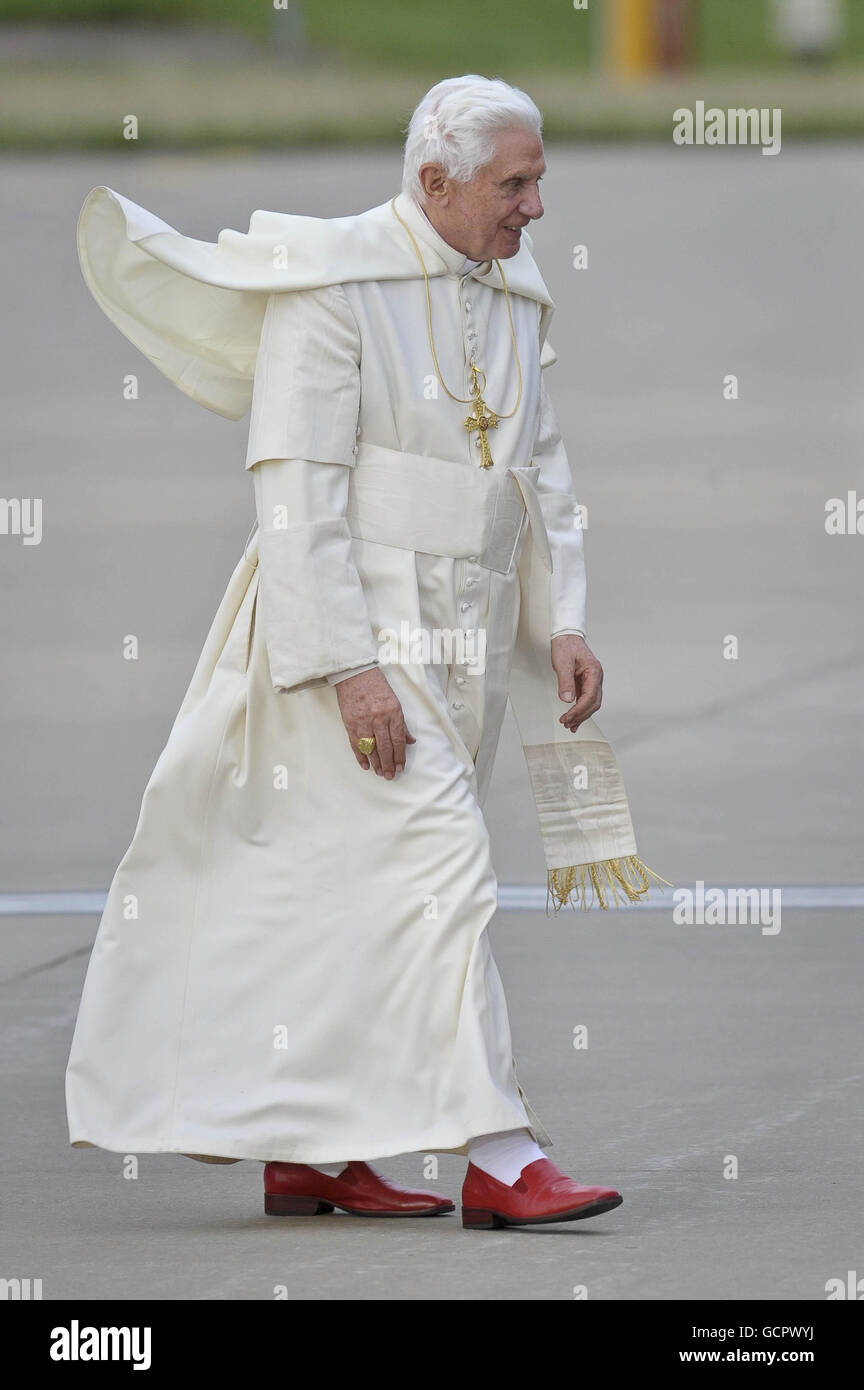 Die Roben von Papst Benedikt XVI. Wehen im Wind, als er am letzten Tag seines Staatsbesuchs in Großbritannien bei einer Abreisezeremonie am internationalen Flughafen Birmingham aus seinem Auto kommt. Stockfoto