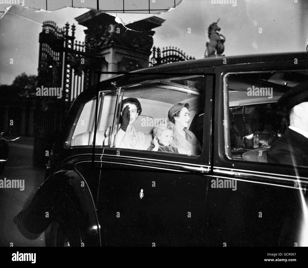 Die Queen und ihre Tochter, Prinzessin Anne, winken der Menge zu, als sie am 19. Mai 1954 den Buckingham Palace zur Euston Station verlassen, um sich nach Balmoral, Schottland, einzuschließen, wo die Queen nach ihrer anspruchsvollen Commonwealth-Tour einen kurzen Urlaub verbringen wird Stockfoto