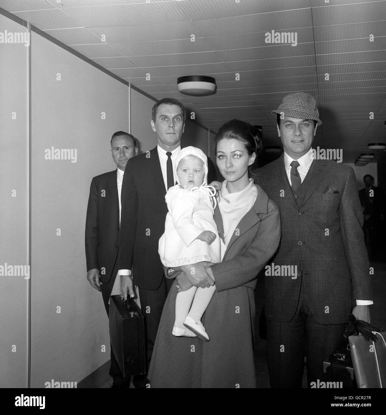 Der amerikanische Schauspieler Tony Curtis, rechts, mit seiner Frau, der deutschen Schauspielerin Christine Kaufmann, und ihrer 14 Monate alten Tochter Alexandra am Flughafen Heathrow. Stockfoto