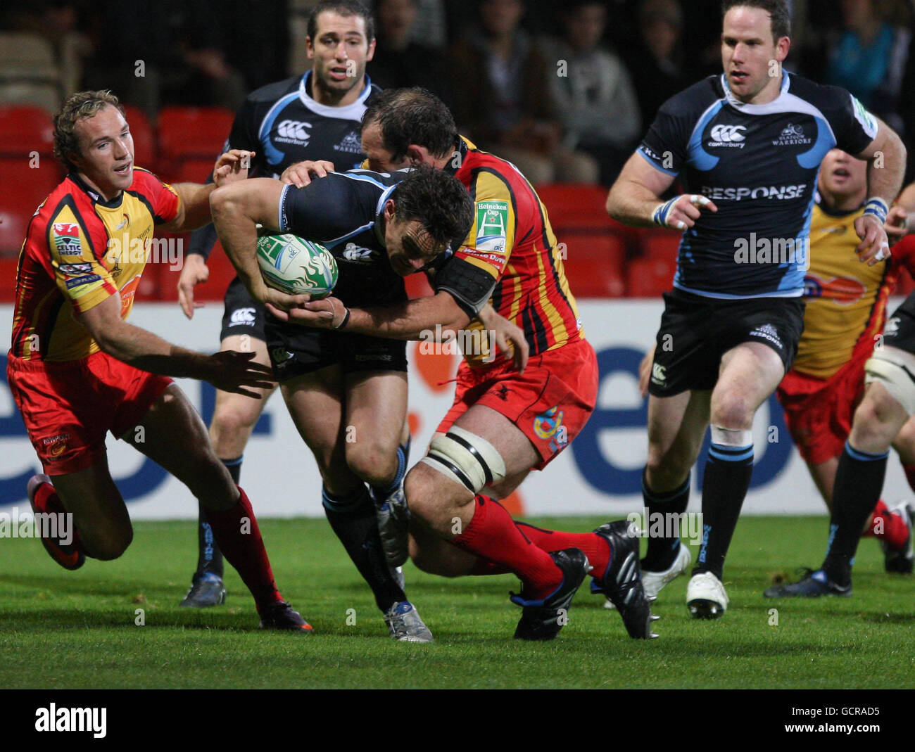Max Evans von Glasgow Warriors (zweiter links) hält die Drachenverteidigung während des Heineken Cup, Pool 6-Match in der Firhill Arena, Glasgow, aus. Stockfoto