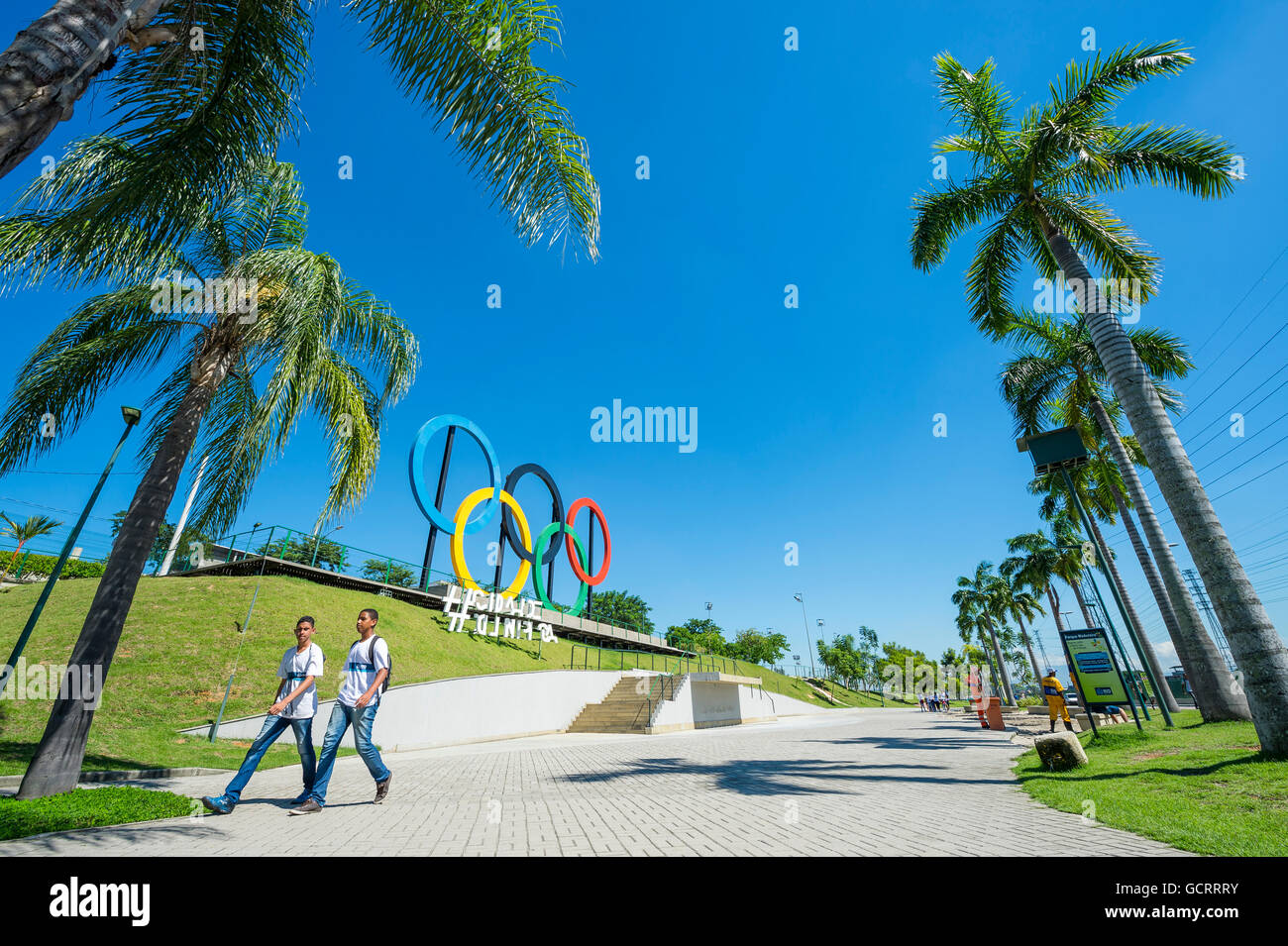RIO DE JANEIRO - 18. März 2016: Junge Brasilianer laufen Sie vor Olympischen Ringe für die Olympischen Sommerspiele 2016 in einem Park installiert. Stockfoto