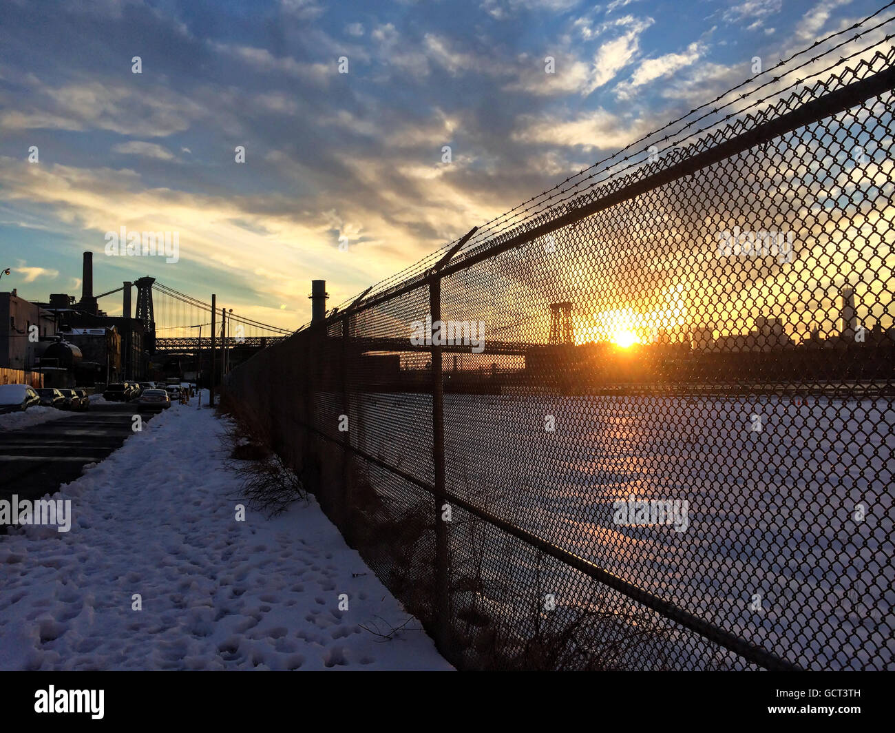 Landschaft der Sonnenuntergang und Williamsburg Bridge durch Maschendrahtzaun betrachtet. Stockfoto