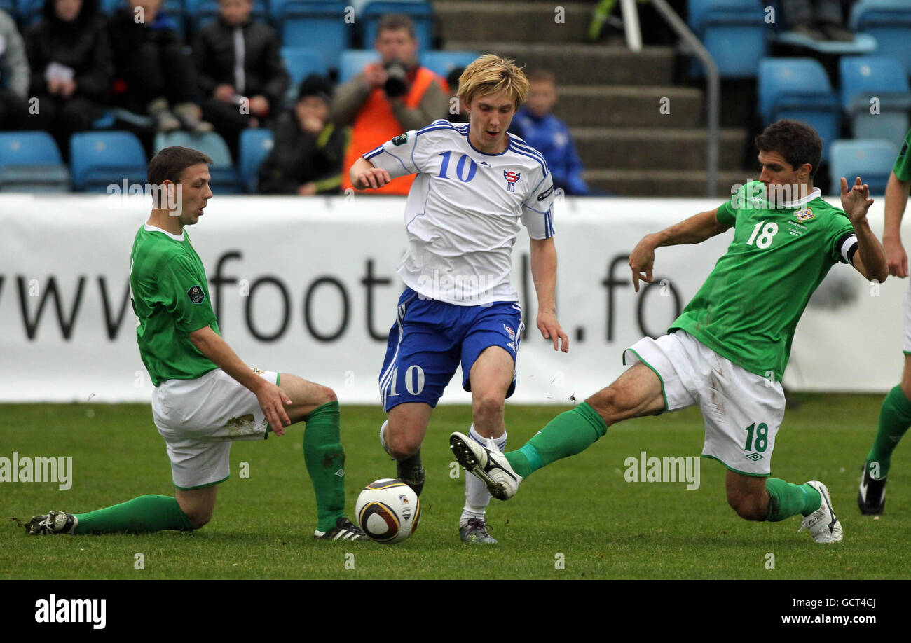 Joan Edmundsson (Mitte) der Färöer-Inseln wird während des UEFA-EM-Qualifying-Spiels 2012 auf Svangaskard, Toftir, Färöer-Inseln von Chris Baird und Aaron Hughes (rechts) in Nordirland herausgefordert. Stockfoto