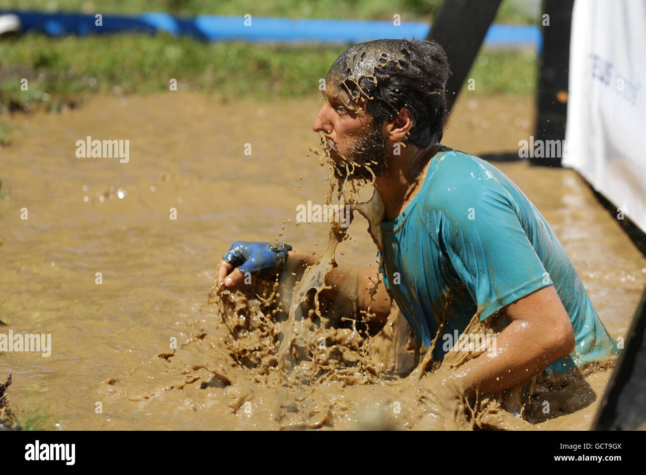 Sofia, Bulgarien - 9. Juli 2016: Ein Teilnehmer in schlammigem Wasser bei der Legion laufen Extremsport-Challenge in der Nähe von Sofia springt. Stockfoto