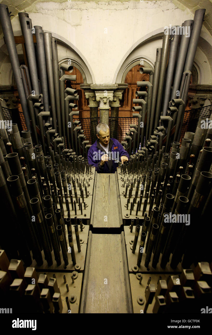 Orgel Tuner David Wintle bei der Arbeit im Orgelloft der Canterbury Cathedral in Canterbury, Kent, während er eine von über 3000 Pfeifen im Loft spielt, aus denen die Orgel besteht, von der einige Teile über 300 Jahre alt sind. Stockfoto