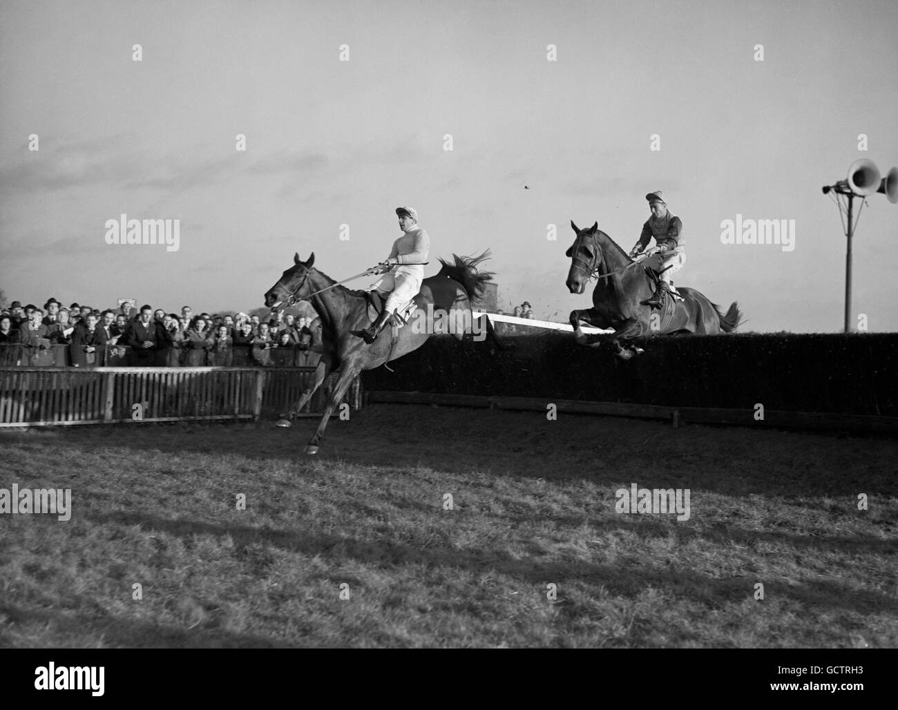 Die von Tony Grantham gerittene Staatskunst nimmt den letzten Zaun ein, um den König George VI. Kirchturm Chase im Kempton Park zu gewinnen. Nur den Zaun zu nehmen, ist E.S.B, Johnny Bullock, der zweite war. Stockfoto