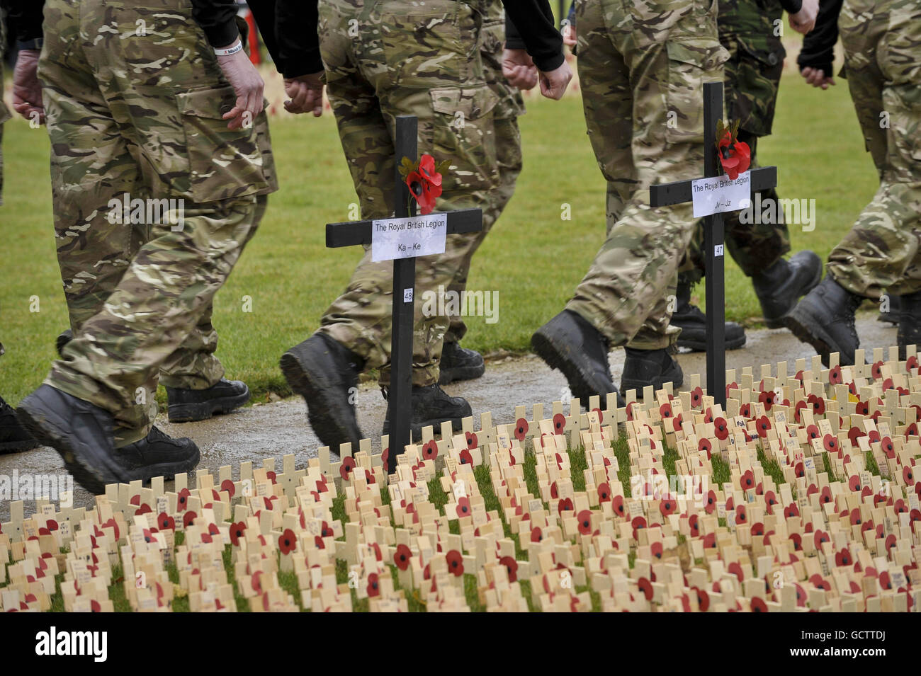 Soldaten marschieren an Kreuzen vorbei, die im Royal British Legion Wootton Bassett Field of Remembrance auf dem Gelände des Lydiard Park, Wiltshire, gepflanzt wurden. Stockfoto