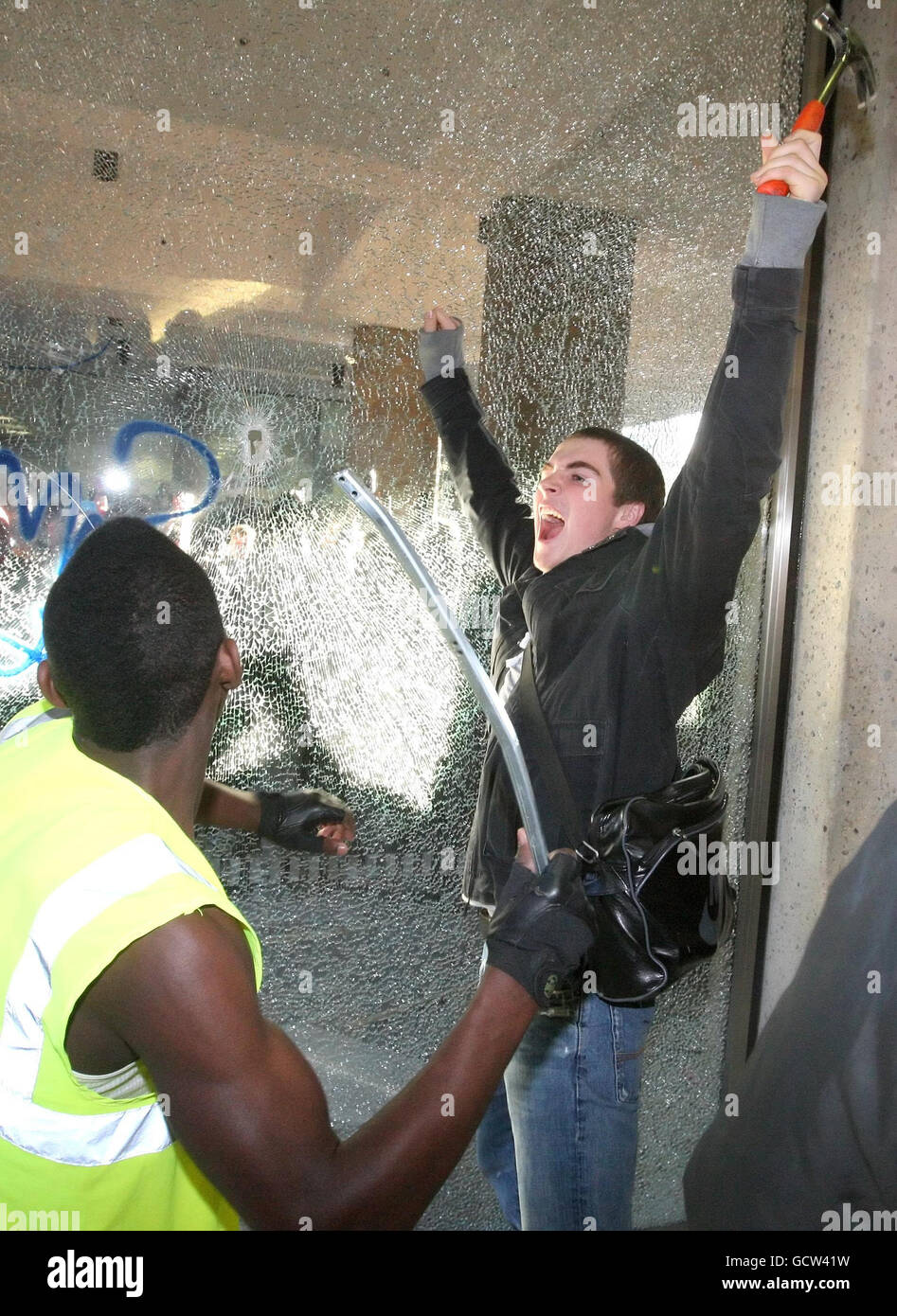 Demonstranten zerschlagen die Fenster des Millbank Tower in Westminster, im Zentrum von London, als Studenten und Lehrer sich im Zentrum von London versammelten, um gegen Kürzungen der Universitätsfinanzierung zu protestieren und die Regierung plant, ab 2012 bis zu 9,000 pro Jahr an Gebühren zu erheben. Stockfoto