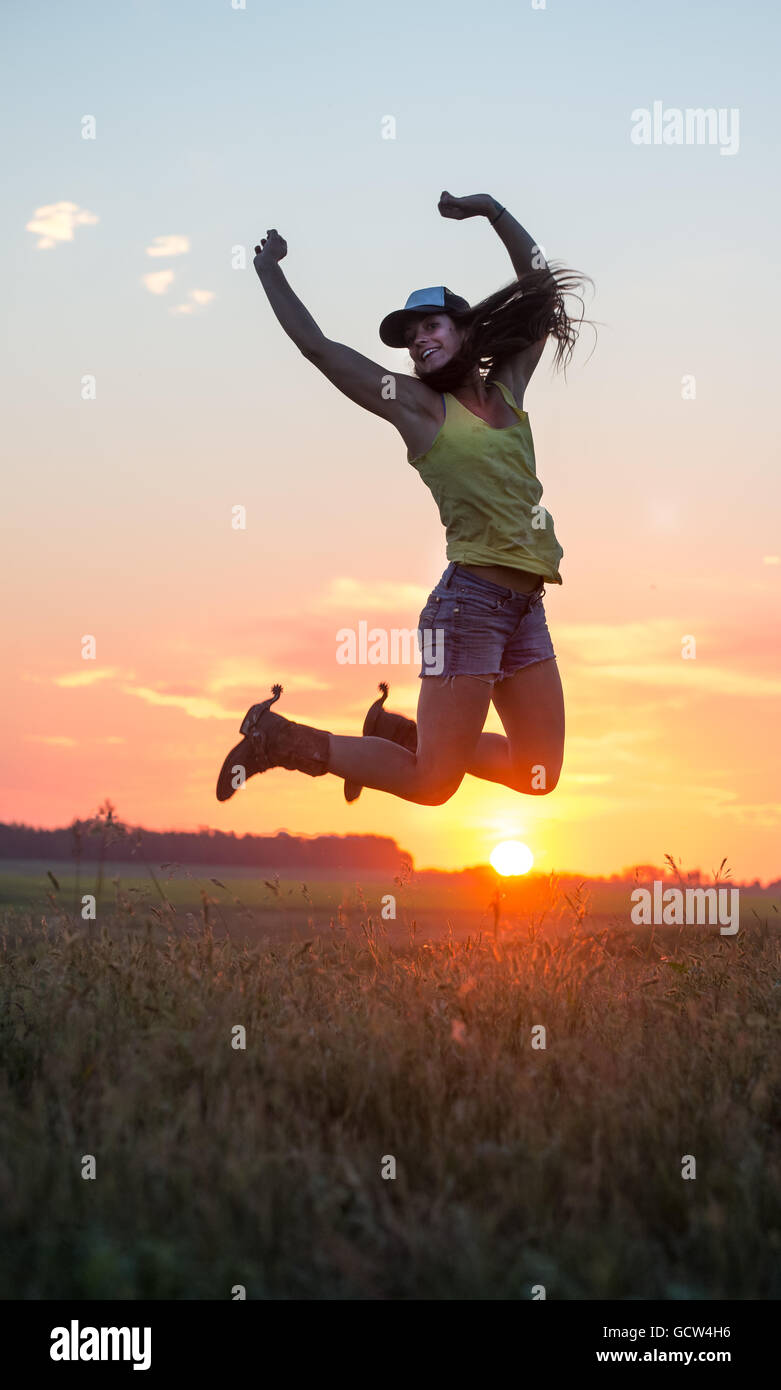 Cowgirl springen vor Freude bei Sonnenuntergang Stockfoto