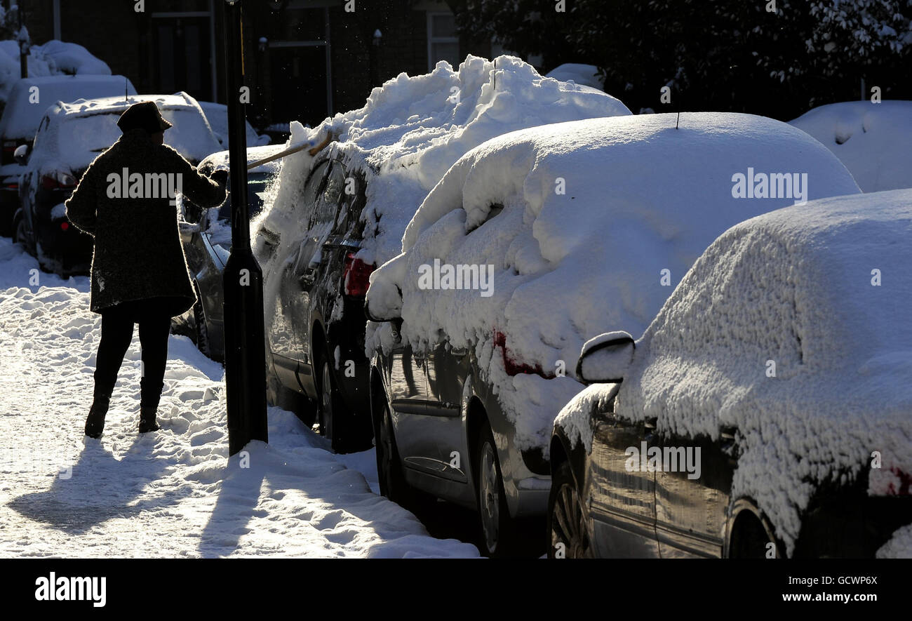 Eine Frau rauscht heute in einer terrassenförmigen Straße in Gateshead den Schnee eines Autos als dicke Schneedecke im Nordosten. Stockfoto