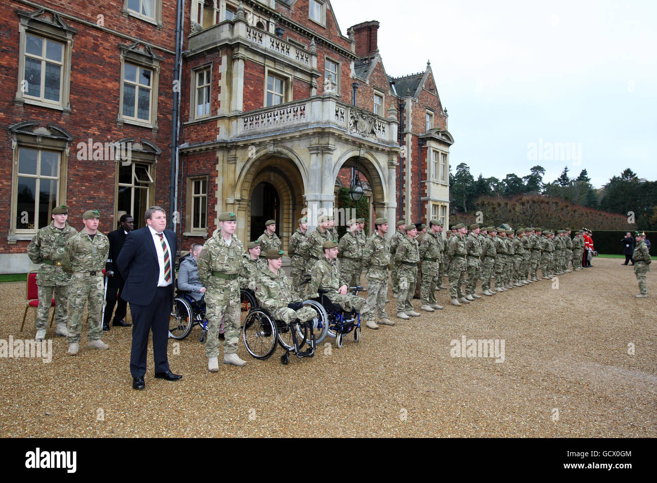 Servicemitarbeiter des 1. Batallions das Mercian Regiment, darunter der Privatangestellte Mitchell Tyler (ganz links in Zivilkleidung), warten darauf, während einer Zeremonie für das , im Sandringham House, Norfolk, von den Geschenken des Prinzen von Wales mit Afghanistan-Wahlkampfmedaillen überreicht zu werden. Stockfoto