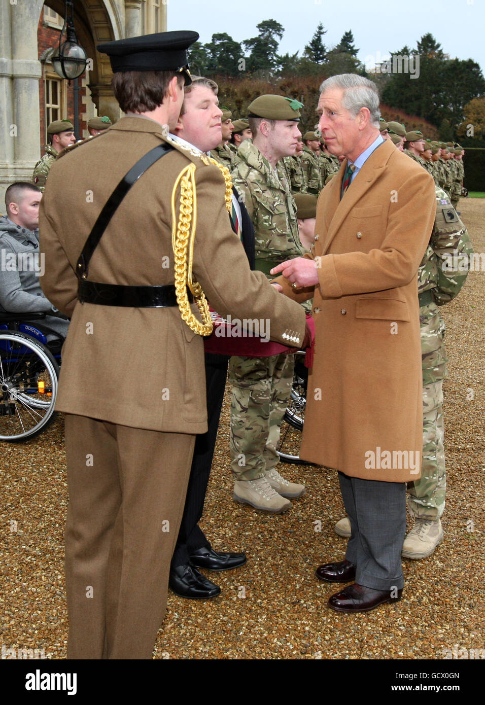 Servicemitarbeiter des 1. Batallions das Mercian Regiment, darunter der Private Mitchell Tyler (Mitte in Zivilkleidung), warten darauf, während einer Zeremonie für das , im Sandringham House, Norfolk, von dem Prinz von Wales Geschenke für die Afghanistan-Kampagne erhalten zu werden. Stockfoto