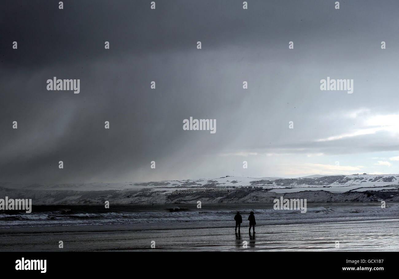 Die Menschen laufen am Strand in Filey, North Yorkshire, da an der Ostküste Großbritanniens mehr Schneefälle vorhergesagt werden. Stockfoto