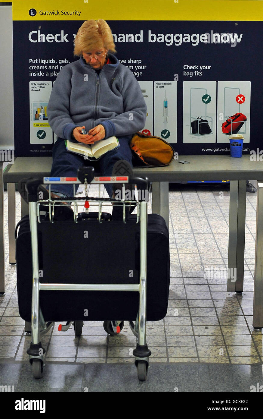 Ein Passagier am Flughafen Gatwick findet einen Platz zum Lesen, da die Flüge für den Rest des Tages gestrichen werden, da große Teile Großbritanniens heute zum Stillstand gekommen sind, als der große Frost die Nation in den Griff zog. Stockfoto