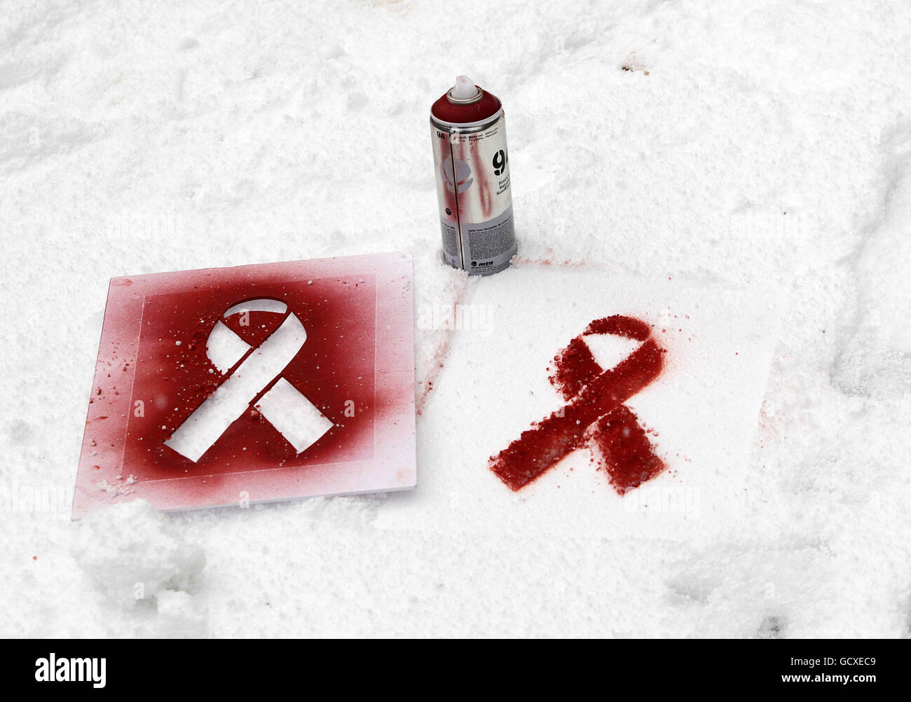Eine Sprühdose und eine Schablone liegen im Schnee von 'Artivisten' will St Leger, der zum Welt-Aids-Tag im Stadtzentrum von Dublin rote Bänder in den Schnee gesprüht hat. Stockfoto