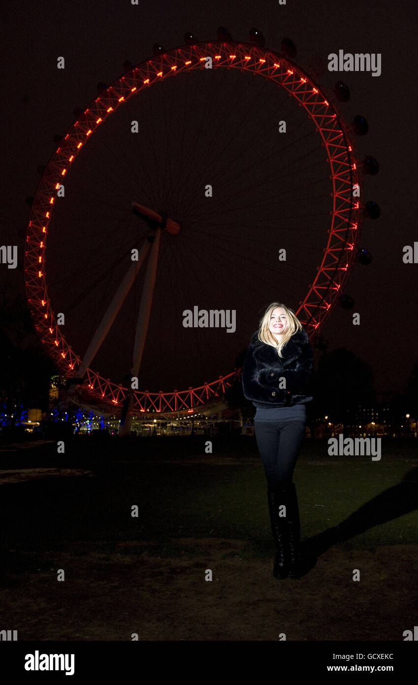 (ROT) die Unterstützerin Sienna Miller steht vor dem London Eye, das rot beleuchtet wurde, um das erreichbare Ziel einer Generation von Babys hervorzuheben, die bis 2015 am Welt-Aids-Tag HIV-frei geboren wurden. Stockfoto