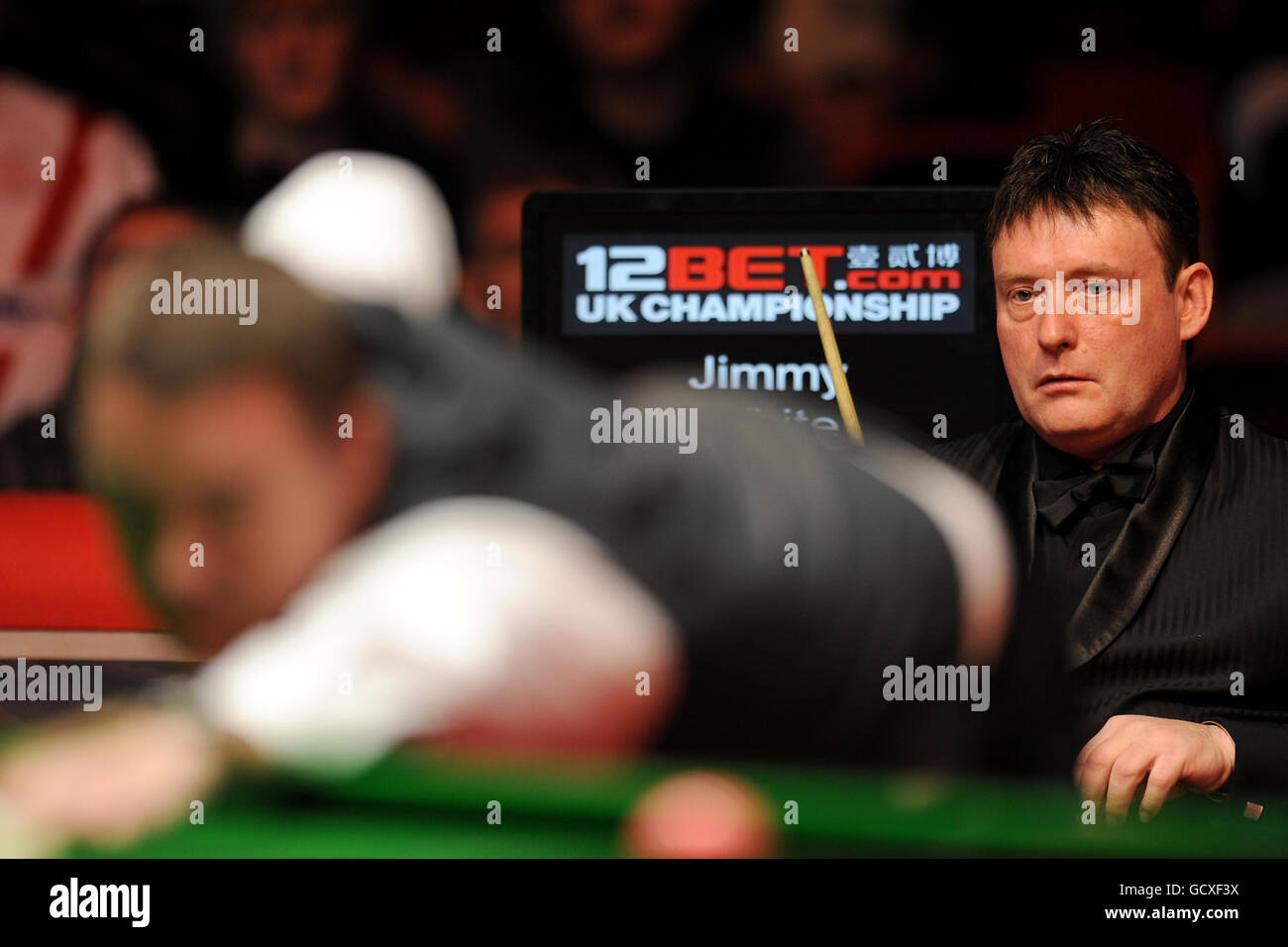 Der englische Jimmy White (rechts) sieht zu, wie der schottische Stephen Hendry während ihres ersten Runden-Spiels während der UK Championships 12Bet.Com im Telford International Center, Telford, Punkte aufstellt. Stockfoto