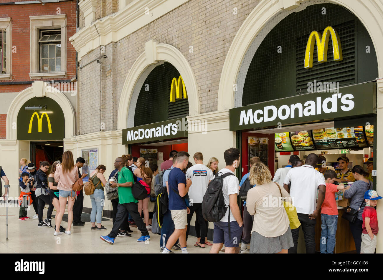 Menschen in die Warteschlange auf eine McDonalds-Filiale in London Victoria Station. Stockfoto