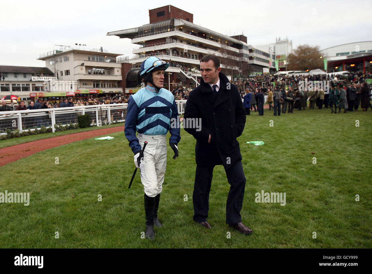 Jockey Tony McCoy geht mit Trainer um den Paradering Evan Williams vor der internationalen Hürde StanJames.com Stockfoto