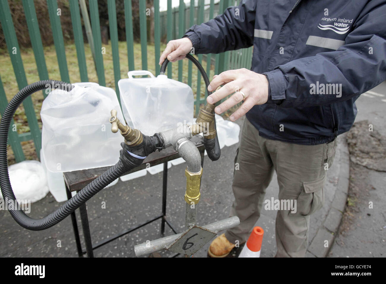 Ein Mitarbeiter von Northern Ireland Water füllt Plastikbehälter für die Öffentlichkeit außerhalb des Firmenhauptsitzes in Nord-Belfast. Stockfoto
