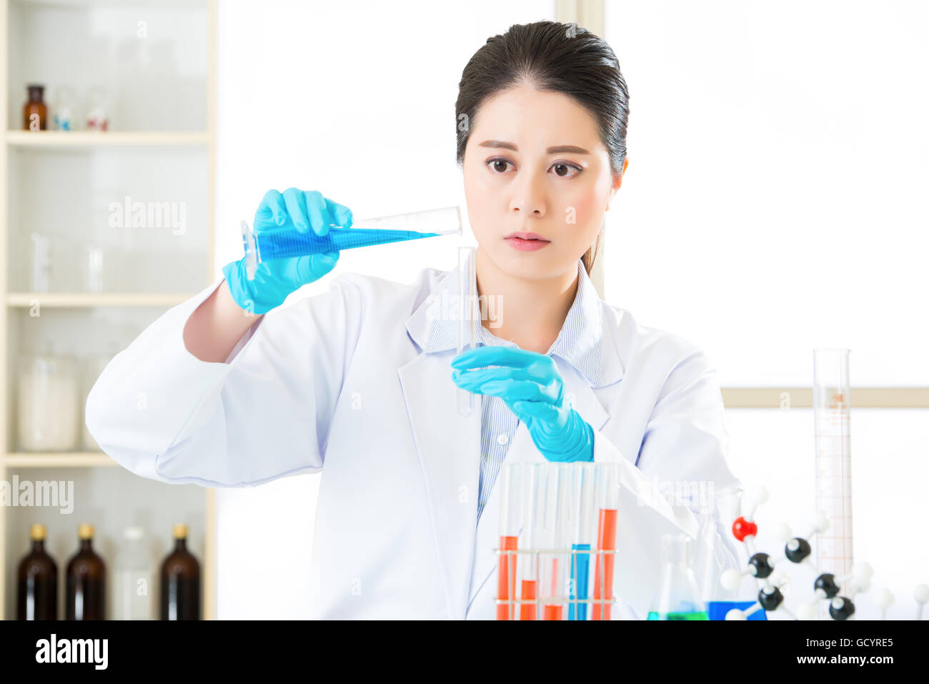 Junge asiatische Wissenschaftler im Bereich Life Science im Labor mit Handschuhen pipettieren Stockfoto