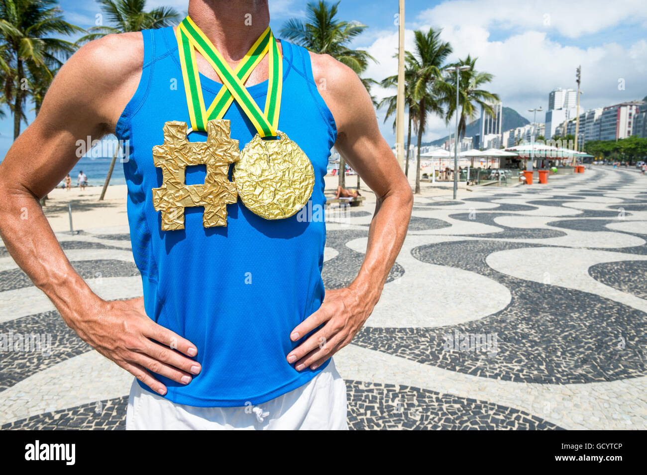 Athlet mit Hashtag Goldmedaille stehend auf den gemusterten Fliesen von der Promenade am Strand der Copacabana in Rio De Janeiro, Brasilien Stockfoto