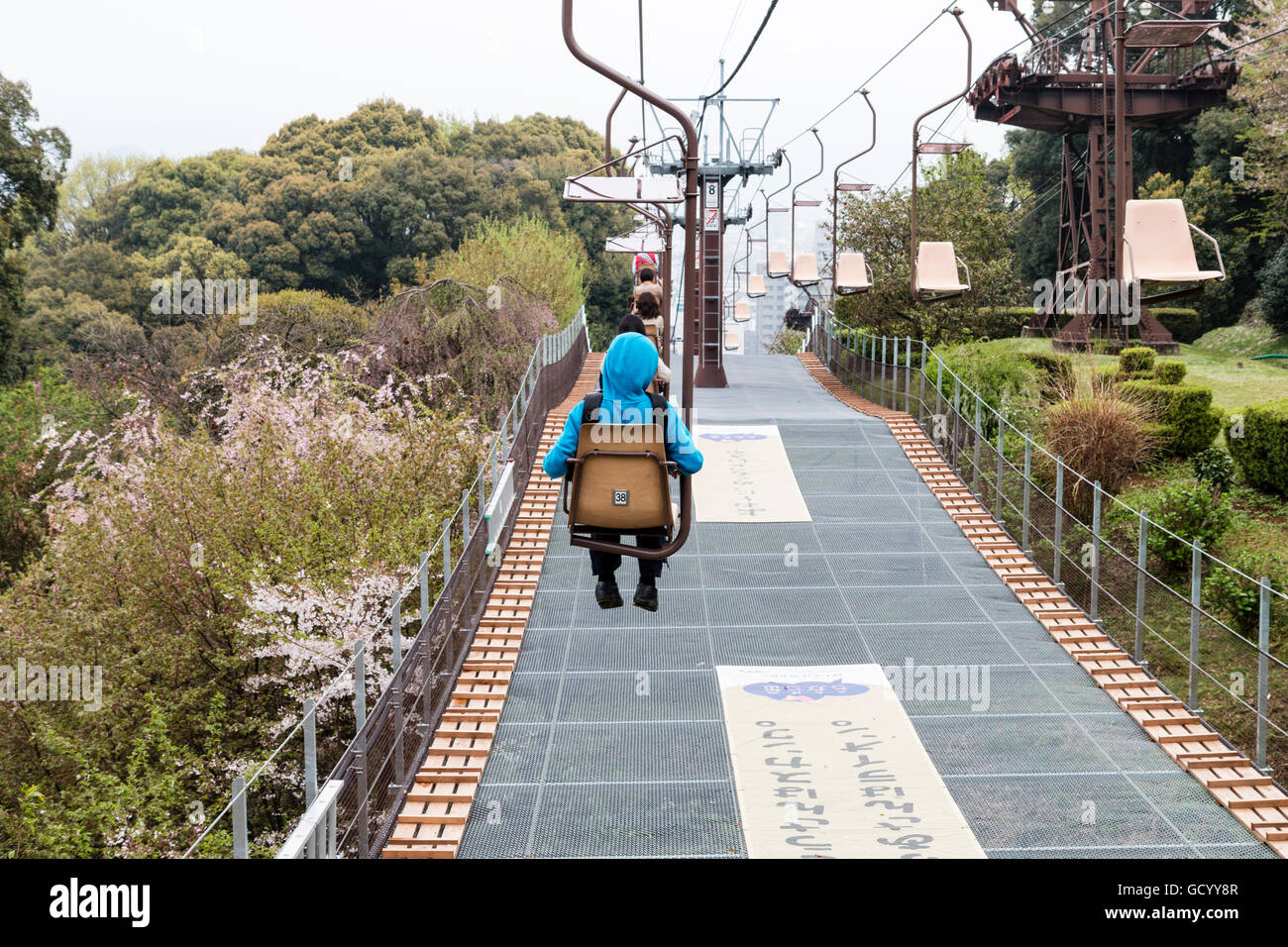 Japan, Iyo Matsuyama Schloss. Seilbahn, Sessellift, auf und zusammen mit der Stadt Hintergrund mit kleinen Jungen vorne in blau Hoodie Top. Stockfoto