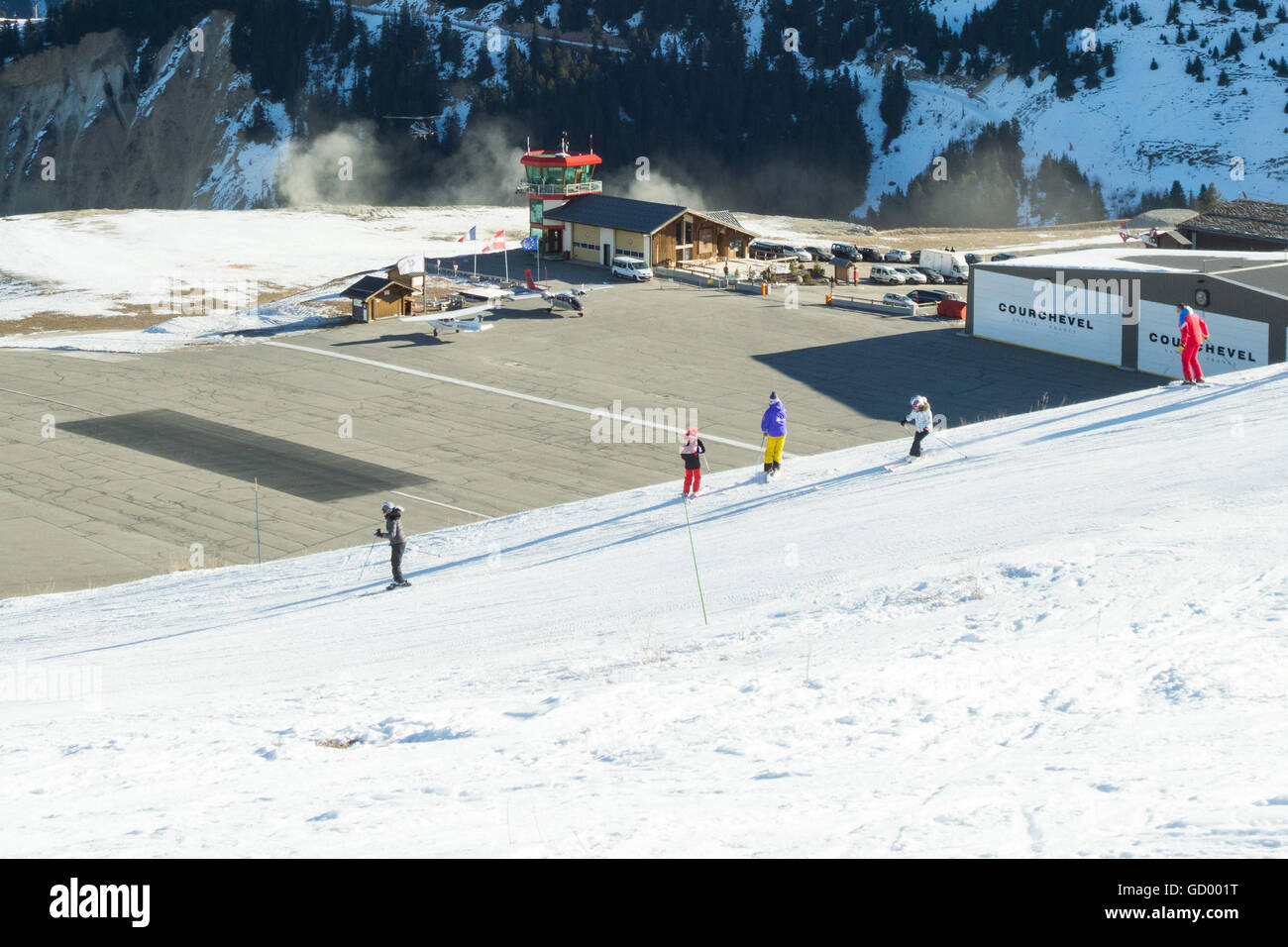 Courchevel 1850 Ski Resort Flughafen - Skifahrer auf der Piste beobachten eines Hubschraubers von Courchevel Flughafen abfliegen Stockfoto