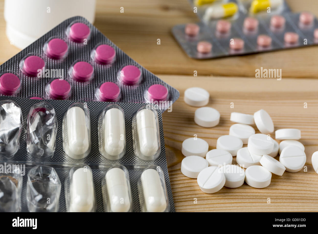 Haufen Medizin bunte Pillen Blister Pack und Wasserglas Stockfoto