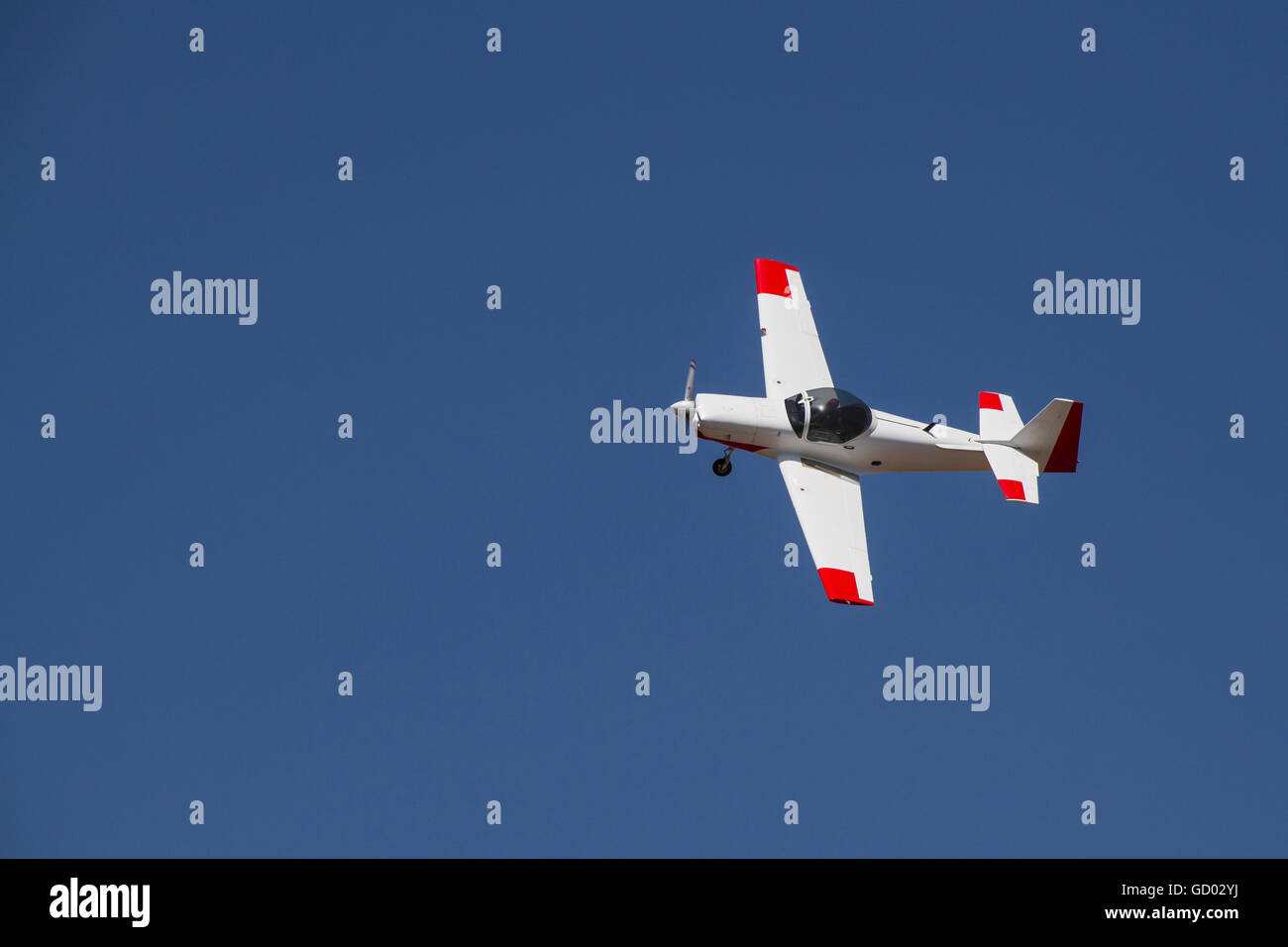 Draufsicht der kleinen weißen Flugzeug fliegen am strahlend blauen Himmel Stockfoto