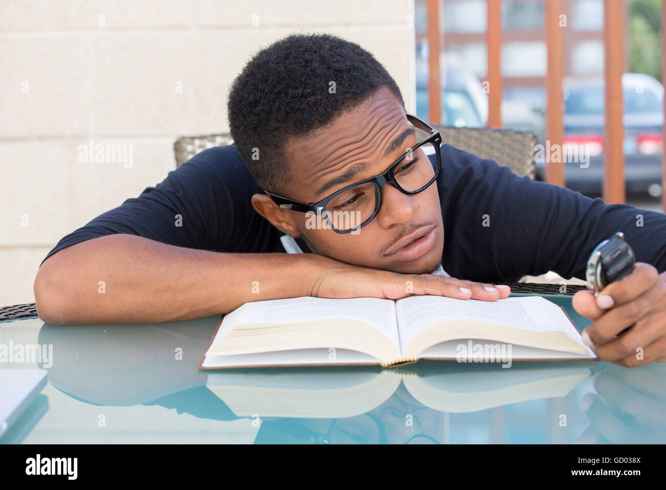 Closeup Portrait, nerdy junge Mann in großen schwarzen Gläsern halten sehen, fallen sehr müde des Lesens, isoliert im freien außen b Stockfoto