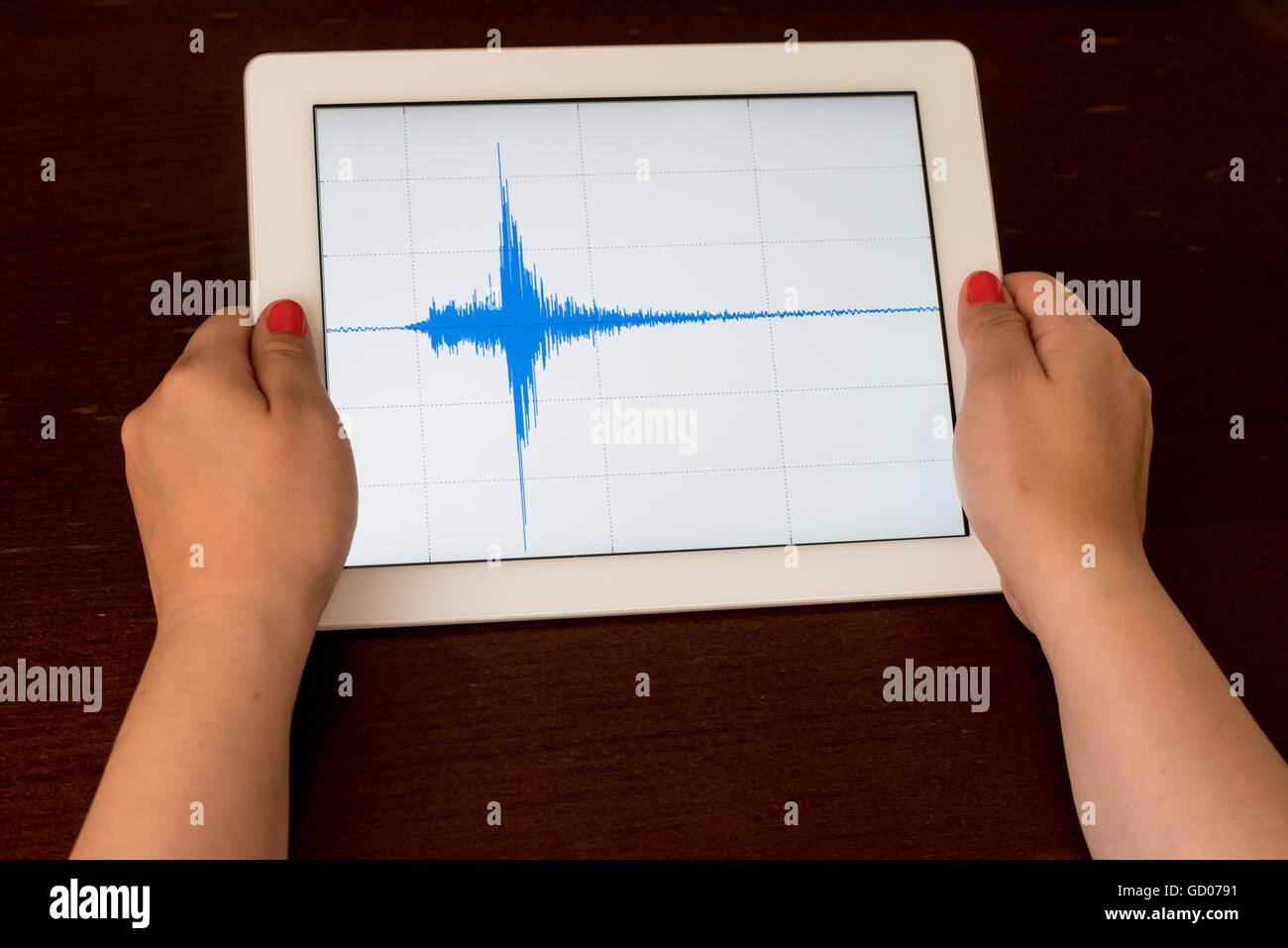 Frau Hand zeigt eine blaue Erdbeben mit einem weißen Hintergrund auf eine weiße Tablette Stockfoto