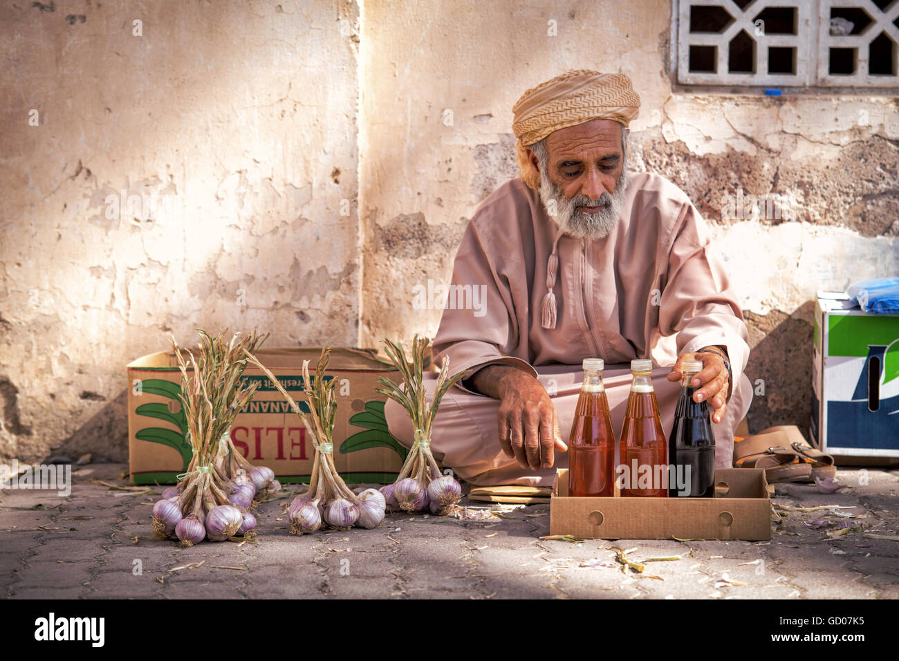 NIZWA, OMAN - 24 APRIL 2015:Omani Greis, Verkauf von Honig und Knoblauch auf dem traditionellen Markt oder Souk in Nizwa, Oman Stockfoto